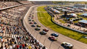 NASCAR race cars speeding on a track with full grandstands.