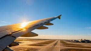 Airplane taking off over airport tarmac.